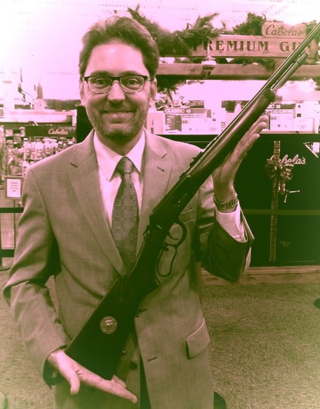 Oregon gun rights attorney Michael Romano holding a lever-action rifle at a sporting goods store